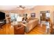 Inviting living room featuring hardwood floors, leather furniture and access to the kitchen at 39939 Parkinsonia St, Lady Lake, FL 32159