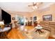 Cozy living room with hardwood floors, a leather sofa, and sliding glass doors to the patio at 39939 Parkinsonia St, Lady Lake, FL 32159
