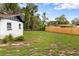 Backyard with a modern house design adjacent to ample outdoor space, complemented by a wooden fence at 4116 Sw 20Th St, Ocala, FL 34474
