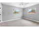 Bedroom with neutral carpet, ceiling fan, and dual windows providing natural light at 4116 Sw 20Th St, Ocala, FL 34474