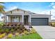 Charming single-story home with a well-manicured lawn and a gray two-car garage at 427 Shoreview Sands Ave, Mascotte, FL 34753