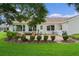 Rear exterior featuring large manicured yard, patio, and lush landscaping at 4830 Summerbridge Cir, Leesburg, FL 34748