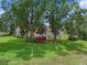 Expansive backyard featuring a well-manicured lawn and mature trees offering ample shade at 4830 Summerbridge Cir, Leesburg, FL 34748