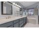 Bathroom with double vanity, soaking tub, marble tile, and decorative blue cabinets at 4830 Summerbridge Cir, Leesburg, FL 34748