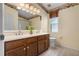 Well-lit bathroom with wood cabinets, double vanity, and decorative floral wallpaper accents at 4830 Summerbridge Cir, Leesburg, FL 34748