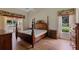 Primary bedroom features a decorative four-poster bed frame and hardwood floors at 4830 Summerbridge Cir, Leesburg, FL 34748