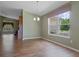Dining room featuring wood floors and a chandelier, complemented by natural light from a large window at 4830 Summerbridge Cir, Leesburg, FL 34748