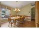 Elegant dining room featuring hardwood floors, wainscoting, a large window, and a chandelier at 4830 Summerbridge Cir, Leesburg, FL 34748