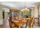Formal dining room featuring hardwood floors, chandelier, china cabinet, and a view to the living room at 4830 Summerbridge Cir, Leesburg, FL 34748