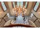 Grand foyer features winding staircase and a stunning chandelier over bright entryway at 4830 Summerbridge Cir, Leesburg, FL 34748