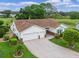 Charming home with a two-car garage, brick-lined driveway, lush landscaping, and a manicured lawn at 4830 Summerbridge Cir, Leesburg, FL 34748