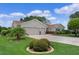 Attractive home featuring a two-car garage, brick accents, tidy landscaping and a manicured lawn at 4830 Summerbridge Cir, Leesburg, FL 34748
