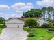 Inviting home with manicured lawn, brick-lined driveway, two-car garage and mature landscaping at 4830 Summerbridge Cir, Leesburg, FL 34748
