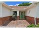 Charming covered front porch with brick flooring, an outdoor seating area and a decorative front door at 4830 Summerbridge Cir, Leesburg, FL 34748