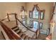 Elegant grand staircase and lobby featuring custom drapery and elegant lighting at 4830 Summerbridge Cir, Leesburg, FL 34748