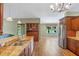 Open kitchen featuring granite countertops, stainless steel appliances, wood cabinets, and a view to the living area at 4830 Summerbridge Cir, Leesburg, FL 34748