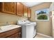 Functional laundry room with modern washer and dryer, ample cabinet space, and a utility sink at 4830 Summerbridge Cir, Leesburg, FL 34748