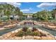 Scenic community waterfall feature with lush landscaping and a charming pedestrian bridge walkway at 4830 Summerbridge Cir, Leesburg, FL 34748