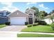 Charming single-story home featuring a well-manicured lawn, paved driveway, and attached two-car garage at 4954 Alavista Dr, Orlando, FL 32837