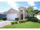 Inviting single-Gathering home featuring a two-car garage, manicured landscaping, and a charming front entrance at 4954 Alavista Dr, Orlando, FL 32837