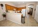 Well-lit kitchen features wooden cabinets, white appliances, and a breakfast bar with a view to the front door at 4954 Alavista Dr, Orlando, FL 32837