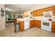 Kitchen with wood cabinets and tile flooring opens to a dining and living area at 4954 Alavista Dr, Orlando, FL 32837