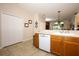 Bright kitchen features wooden cabinets, white appliances and tile flooring, with a view of the backyard at 4954 Alavista Dr, Orlando, FL 32837