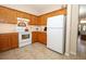 This efficient kitchen features white appliances, honey-colored wood cabinets and tile flooring at 4954 Alavista Dr, Orlando, FL 32837