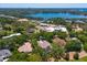 Aerial view of the home with a yellow border on a large property surrounded by lush trees and a lake at 5199 Latrobe Dr, Windermere, FL 34786