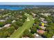 Aerial view of the home on a golf course neighborhood surrounded by lush trees and a lake at 5199 Latrobe Dr, Windermere, FL 34786