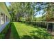 Spacious backyard with lush lawn, iron fence, and mature trees providing plenty of shade at 5199 Latrobe Dr, Windermere, FL 34786
