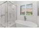 Modern bathroom with a glass shower, soaking tub, and natural light from the windows at 5199 Latrobe Dr, Windermere, FL 34786