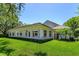 Beautiful home exterior with lush green lawn, white walls, and many windows providing plenty of natural light at 5199 Latrobe Dr, Windermere, FL 34786