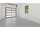 Garage featuring epoxy flooring, modern door and a window with plantation shutters at 5199 Latrobe Dr, Windermere, FL 34786