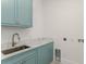 Bright laundry room features light blue cabinets and countertop with marble effect at 5199 Latrobe Dr, Windermere, FL 34786