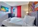 Inviting bedroom featuring a mounted TV, a queen bed, and vibrant decor for a relaxed atmosphere at 6165 Carrier Dr # 2605, Orlando, FL 32819