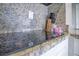 Granite kitchen countertop with black glass cooktop, wooden knife block, and coffee accessories at 6165 Carrier Dr # 2605, Orlando, FL 32819