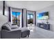 Stylish living room featuring a comfortable couch, balcony access, and a modern entertainment unit at 6165 Carrier Dr # 2605, Orlando, FL 32819