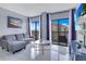 Bright living room showcasing a plush couch, balcony with views, and chic decor at 6165 Carrier Dr # 2605, Orlando, FL 32819
