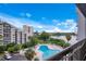 Balcony view overlooking a swimming pool, lake, and neighboring buildings at 6165 Carrier Dr # 2605, Orlando, FL 32819