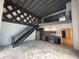 Open living room and kitchen with black staircase, stainless steel appliances, and exposed beams at 62 W Colonial Dr # 302, Orlando, FL 32801