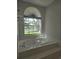 Bright bathroom with a garden tub under a large window offering a view of the green neighborhood at 651 Oak Hollow Way, Altamonte Springs, FL 32714