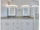 Bathroom vanity with double sinks, illuminated mirrors, granite countertops and white cabinets at 651 Oak Hollow Way, Altamonte Springs, FL 32714