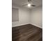 A minimalist bedroom with dark wood-look floors, a ceiling fan, and a neutral-toned wall at 651 Oak Hollow Way, Altamonte Springs, FL 32714