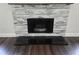 Close-up of modern gas fireplace with decorative stone and black granite hearth at 651 Oak Hollow Way, Altamonte Springs, FL 32714