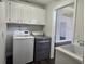 Clean laundry room featuring a washer, dryer, utility sink, and white cabinets at 651 Oak Hollow Way, Altamonte Springs, FL 32714