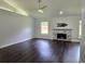 Bright living room with dark wood floors, stone fireplace, and modern ceiling fan at 651 Oak Hollow Way, Altamonte Springs, FL 32714