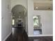 Open-concept living room with stone fireplace, dark floors, arched doorway, and lots of light at 651 Oak Hollow Way, Altamonte Springs, FL 32714
