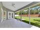 View of a screened porch that leads to a backyard featuring well-maintained grass at 651 Oak Hollow Way, Altamonte Springs, FL 32714