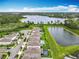 Stunning aerial view of neighborhood homes, streetscape, and a lake, complete with lush landscaping and private backyard pools at 6947 Cucamelon Ct, Windermere, FL 34786